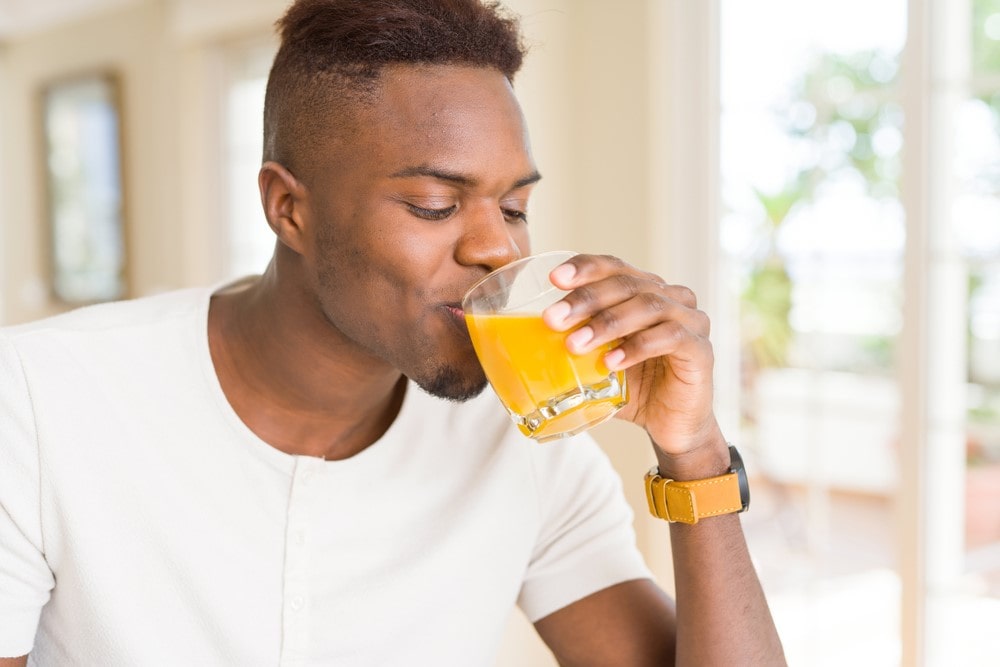 man drinking orange juice